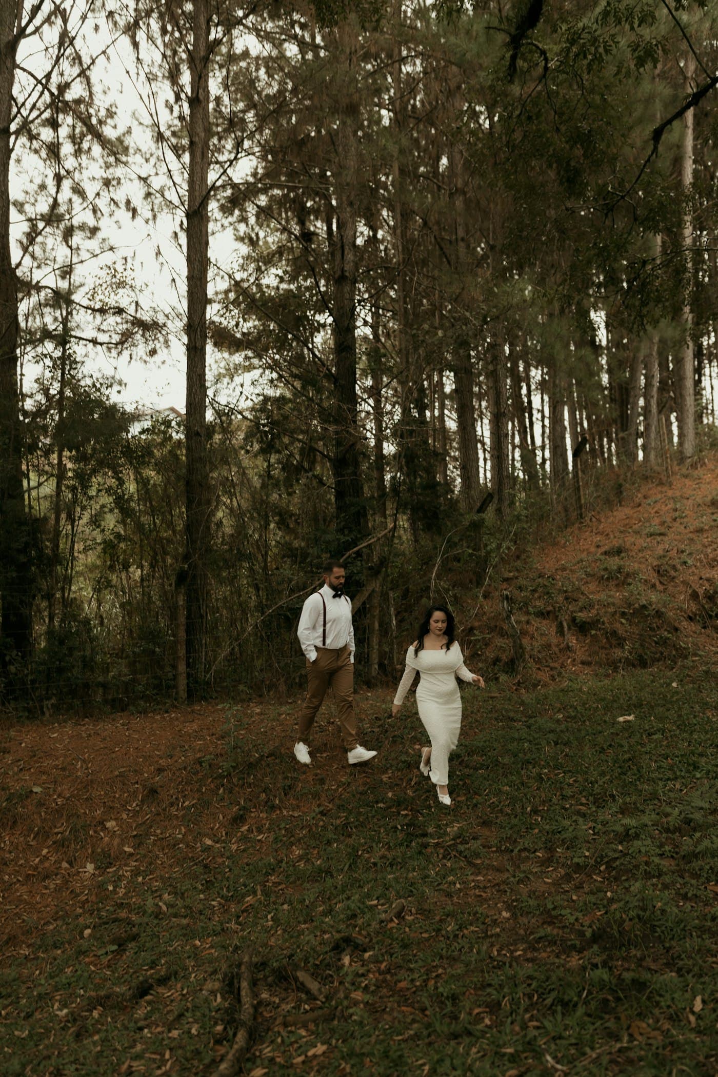 A couple walking a quiet path through tall pines