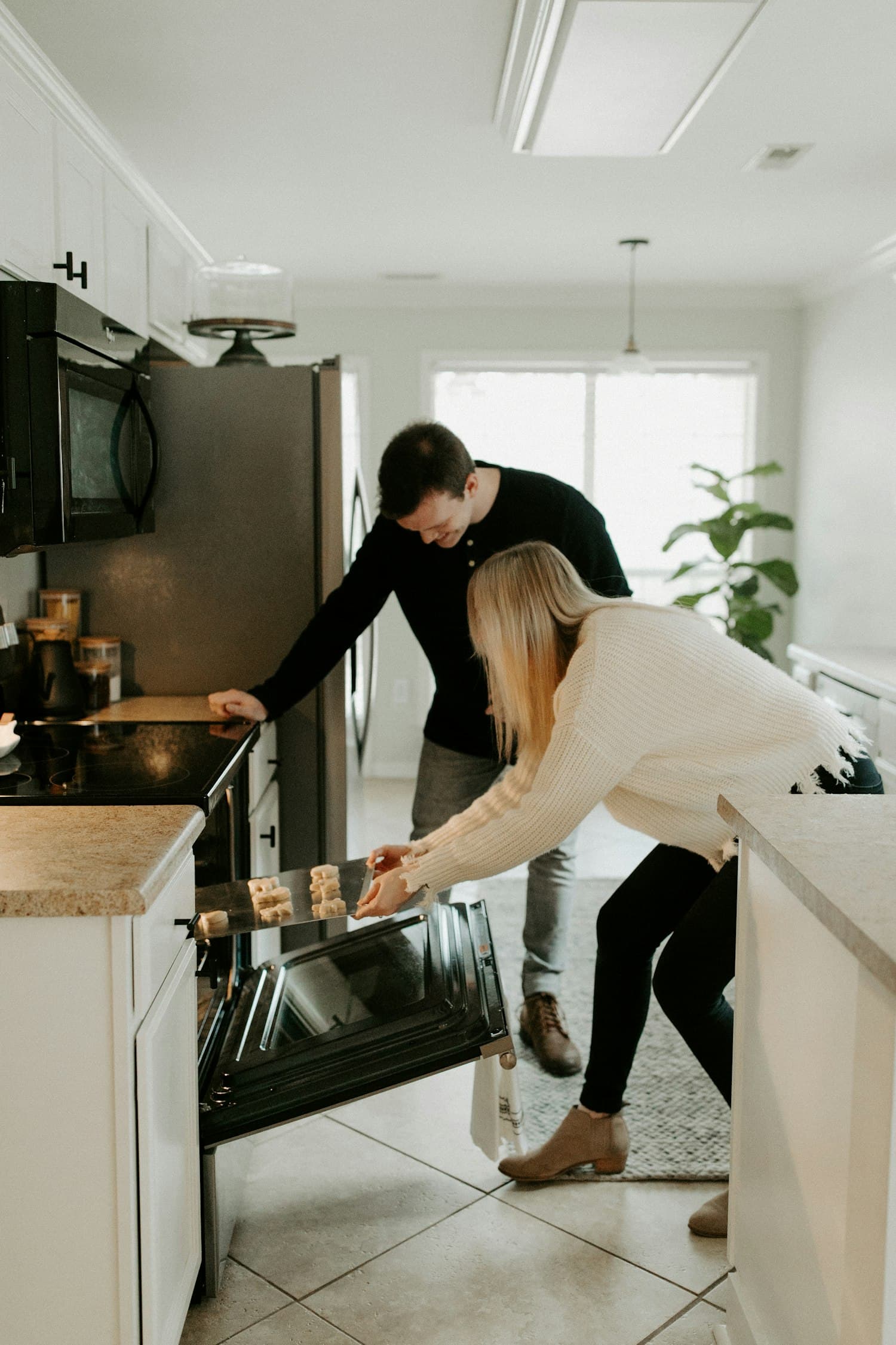 A couple cooking together at the stove in a warm kitchen